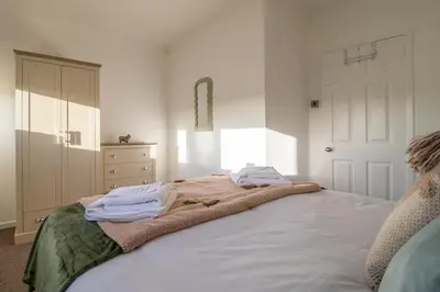 a bedroom with a bed with towels on it at The Bridge- 3 Bedrooms in Coatbridge with Driveway in Moffat