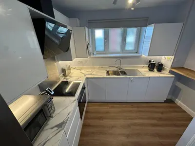 a small kitchen with white cabinets and a sink at 3x Large Double bedroom, Central London flat in Moffat