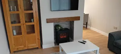 a living room with a fireplace and a tv at Martindale Close - 3 Bedrooms - Sleeps 5 in Whitehaven