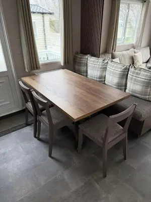 a wooden table and chairs in a living room with a couch at Paws A While in Mainsriddle