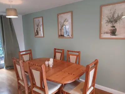 a dining room with a wooden table and chairs at Fabulous 4 Bed House in Leiston in Moffat