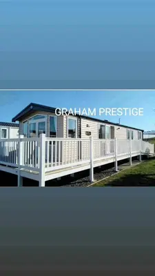 a modular home with a porch and a white fence at Grahams Prestige Craig Tara in Minishant