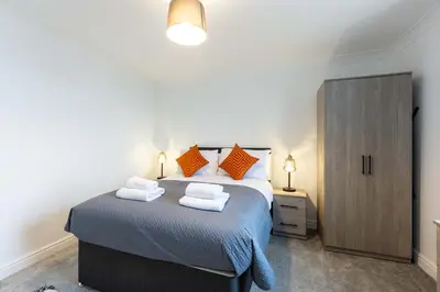 a bedroom with a bed with towels on it at 1 Bed Whitehaven Harbour-side Flat with Sea Views in Whitehaven