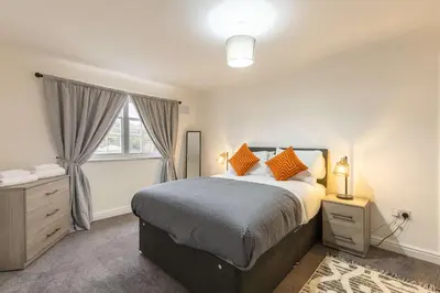 a bedroom with a large bed and a window at Bright 1 Bed Harbour-side Apartment w Sea Views in Whitehaven