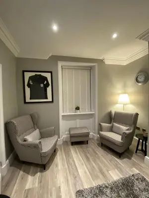 a living room with two chairs and a table at 26 Challoner Street, Cockermouth, CA13 9QS in Cockermouth