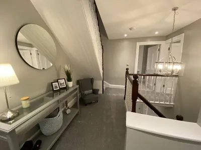 a bathroom with a staircase with a mirror and a sink at 26 Challoner Street, Cockermouth, CA13 9QS in Cockermouth