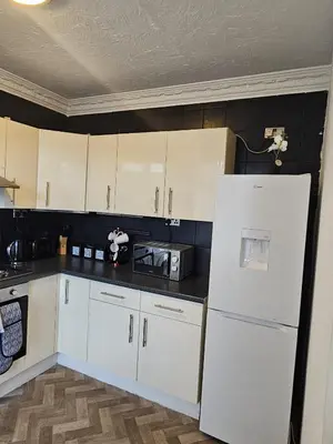 a kitchen with white cabinets and a white refrigerator at Acadia House Blyth in Moffat