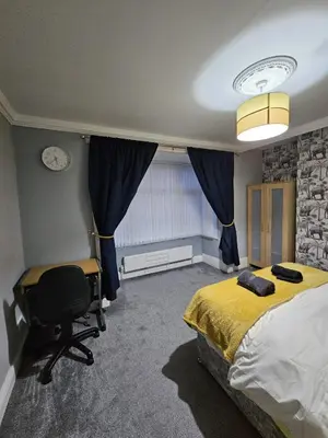 a bedroom with a bed and a desk and a chair at Acadia House Blyth in Moffat
