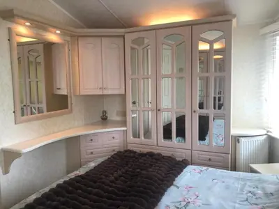 a bedroom with white cabinets and a large bed at 29 The Beeches in Gilcrux