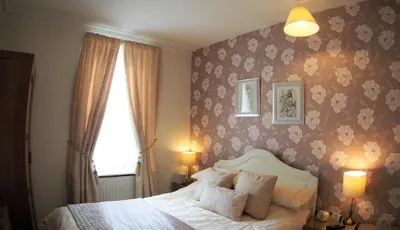 a bedroom with a bed and a flowery wallpaper at Lindisfarne House in Keswick