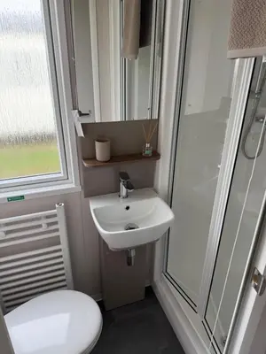 a bathroom with a sink and a shower and a toilet at Paws a while in Mainsriddle