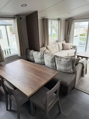 a living room with a table and a couch at Paws a while in Mainsriddle