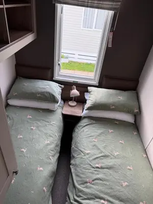 two beds in a small room with a window at Paws a while in Mainsriddle