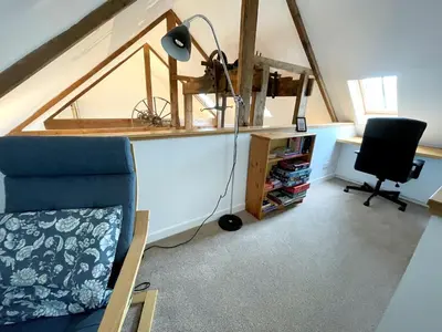 an attic room with a desk and a chair and a lamp at Outstanding Converted Mill in Beautiful Location - Pass the Keys in Gatehouse of Fleet