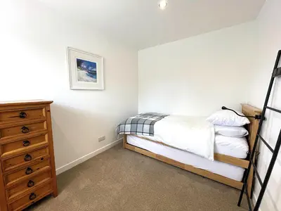 a bedroom with a bed and a dresser at Outstanding Converted Mill in Beautiful Location - Pass the Keys in Gatehouse of Fleet