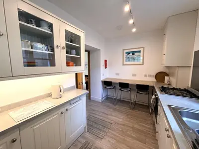a kitchen with white cabinets and a counter top at Beautifully Presented Cosy Home in Kirkcudbright - Pass the Keys in Kirkcudbright