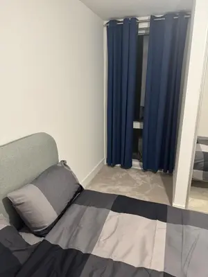 a bedroom with a bed with blue curtains at Colindale Condominium in Moffat