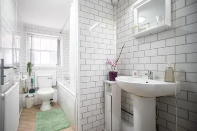 a white bathroom with a sink and a toilet at Newton Flat in Carlisle