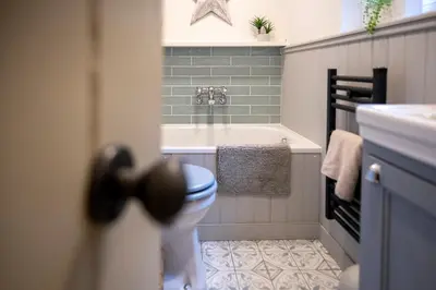 a bathroom with a bath tub and a toilet at Tegfryn in Moffat