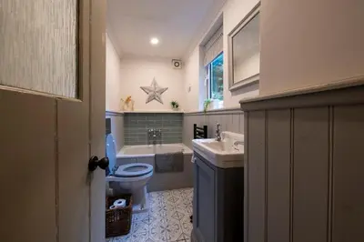 a bathroom with a toilet and a sink and a tub at Tegfryn in Moffat