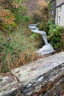 a stream of water next to a road with snow at Tegfryn in Moffat
