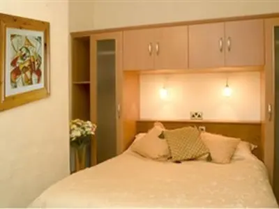 a bedroom with a bed with pillows on it at Arrandale House in Douglas