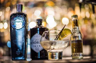 a table with bottles of alcohol and a drink at Mount Stewart Hotel in Portpatrick