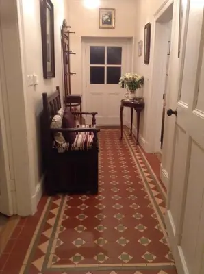 a hallway with a door and two chairs and a rug at The Dash Farmhouse in Bassenthwaite