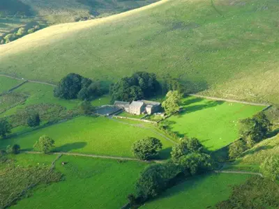 an aerial view of a house in a green field at The Dash Farmhouse in Bassenthwaite