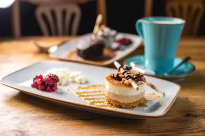 a plate with a piece of cake and a cup of coffee at The Manor in St Bees