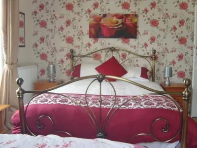 a bedroom with a bed with a red blanket and flowers at Telford Manor House in Beattock