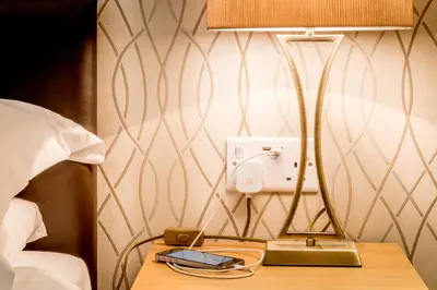a lamp on a table next to a bed at Hermiston Guest House in Keswick