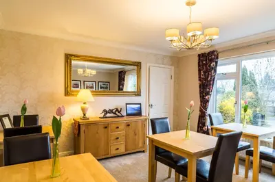 a dining room with a table and chairs and a mirror at Hermiston Guest House in Keswick