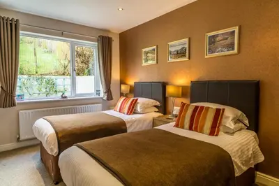 a hotel room with two beds and a window at Hermiston Guest House in Keswick