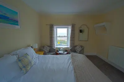 a bedroom with a large bed and a window at The Harbour Inn in Garlieston