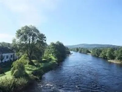 a river with trees on the side of it at The Ken Bridge Hotel & Campsite in New Galloway