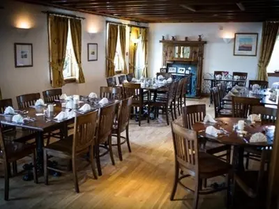 a dining room with wooden tables and chairs at The Ken Bridge Hotel & Campsite in New Galloway