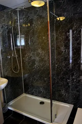 a bathroom with a shower with a bath tub at Crown hotel in Portpatrick