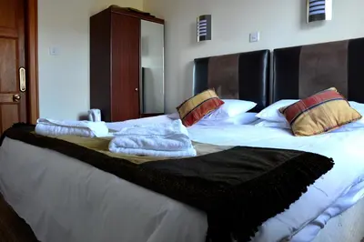 a bedroom with a bed with white sheets and pillows at Crown hotel in Portpatrick