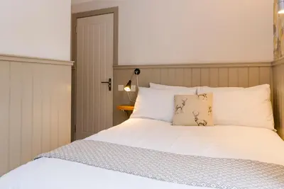 a bedroom with a bed with white sheets and pillows at The Harbour Guest House in Irvine