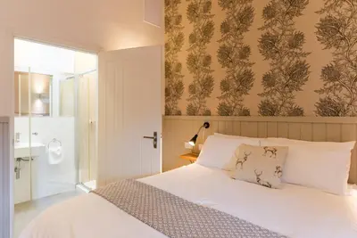 a bedroom with a white bed and a bathroom at Irvine Bay in Irvine