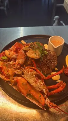 a plate of food with seafood and sauce on a table at Pond Cottage in Covington