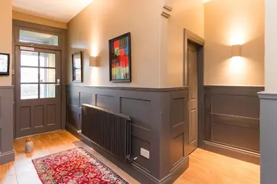 a hallway of a home with a door and a rug at Irvine Guest House in Irvine