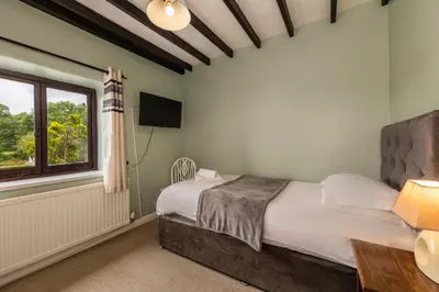 a bedroom with a bed and a window at Bower House Inn in Eskdale