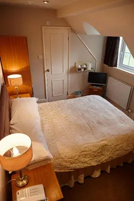 a bedroom with a large bed and a window at Hundith Hill Hotel in Cockermouth