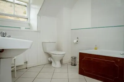 a bathroom with a toilet and a tub and a sink at Stanley House in Eskdale