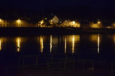 a body of water at night with houses and lights at Cladach in Garlieston