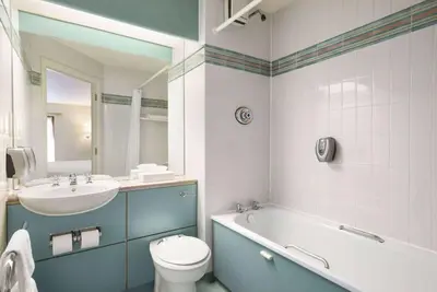 a bathroom with a sink and a toilet and a bath tub at Days Inn Lockerbie - Annandale Water in Johnstonebridge