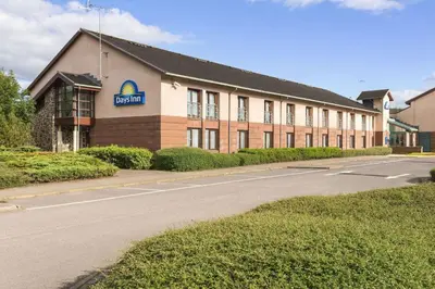 a building with a sign on the side of a road at Days Inn Lockerbie - Annandale Water in Johnstonebridge