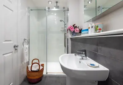 a white bathroom with a sink and a shower at The Mount self-catering in Portinscale